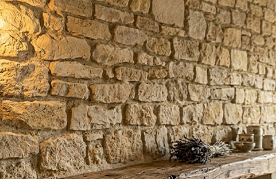 Mur intérieur habillé de plaquettes en quartzite refendu gris et rouille — applique murale réchauffant la texture